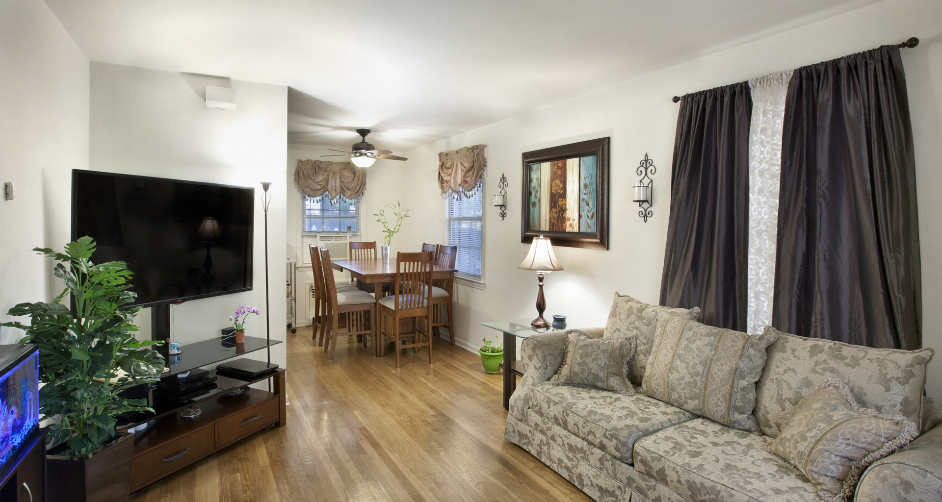 a living room and dining room with a couch and a tv
